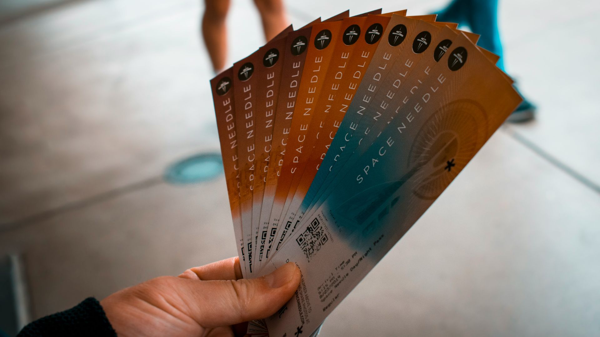 person holding brown, blue, and white tickets