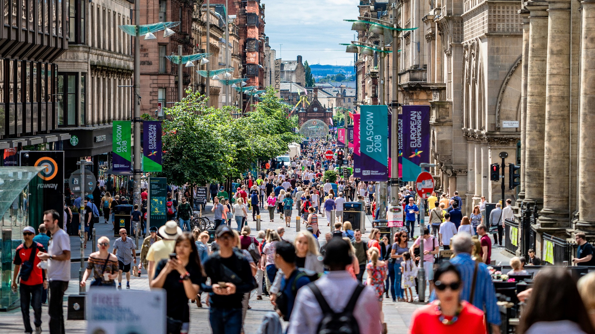people walking between concrete buildings at daytime