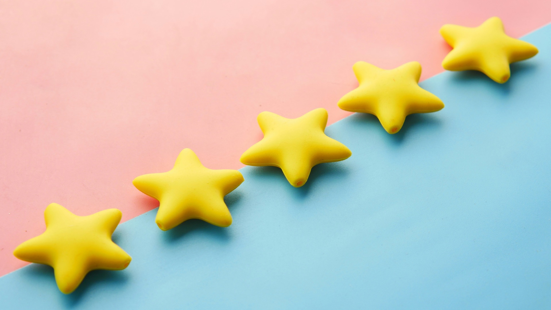 a row of yellow stars sitting on top of a blue and pink surface