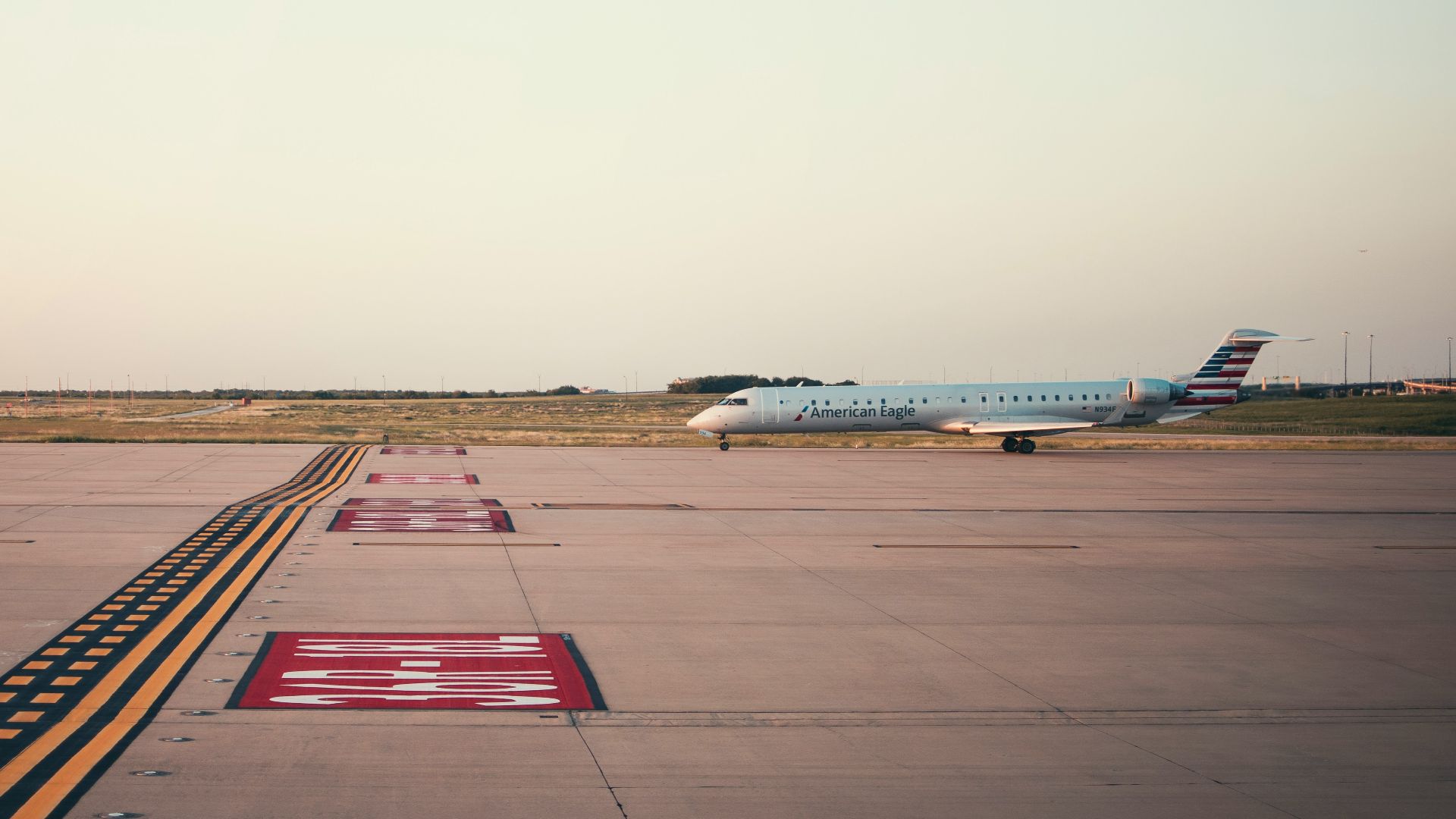white and blue airplane on brown field during daytime