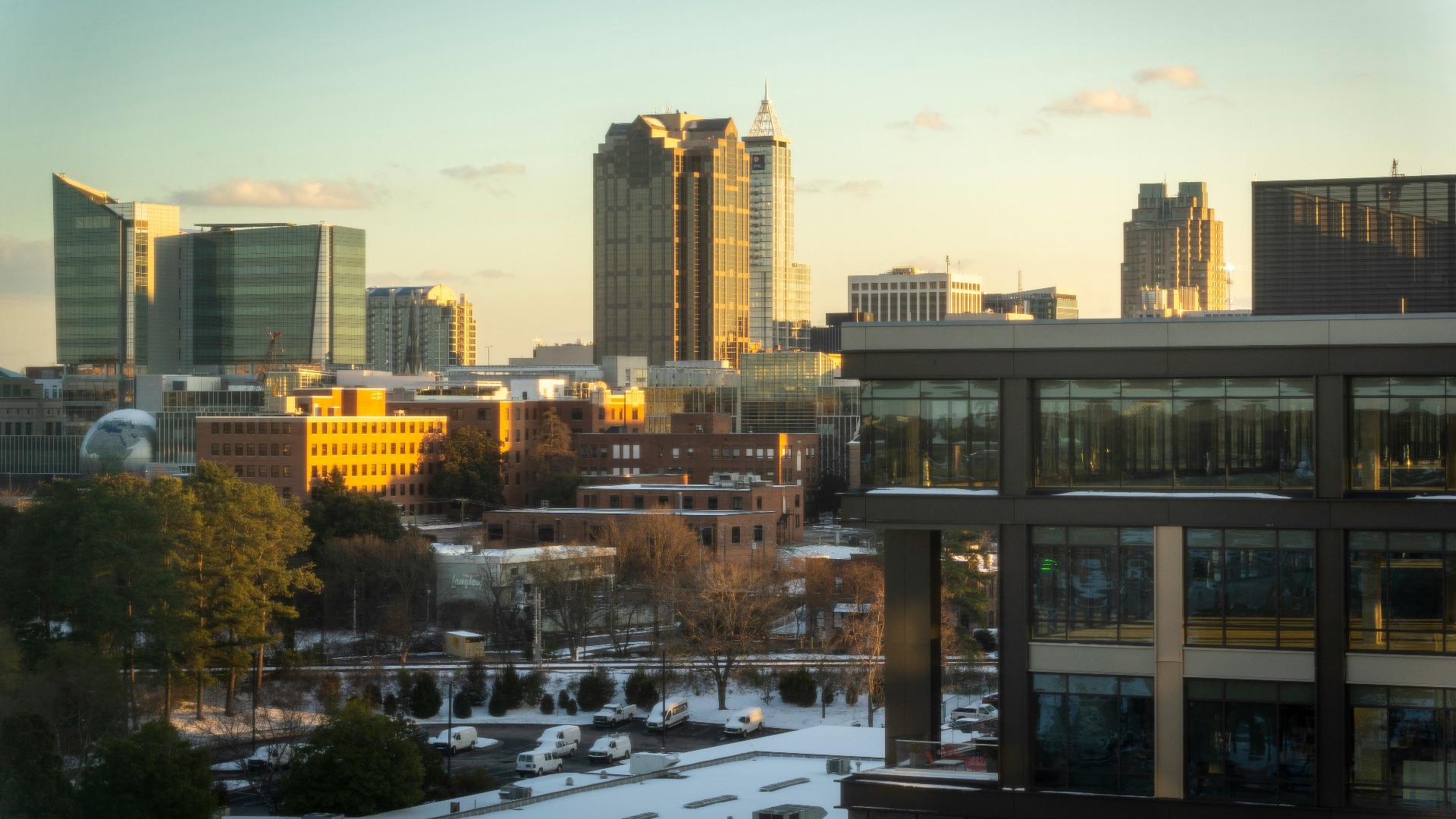Cityscape at sunrise, buildings are lit.