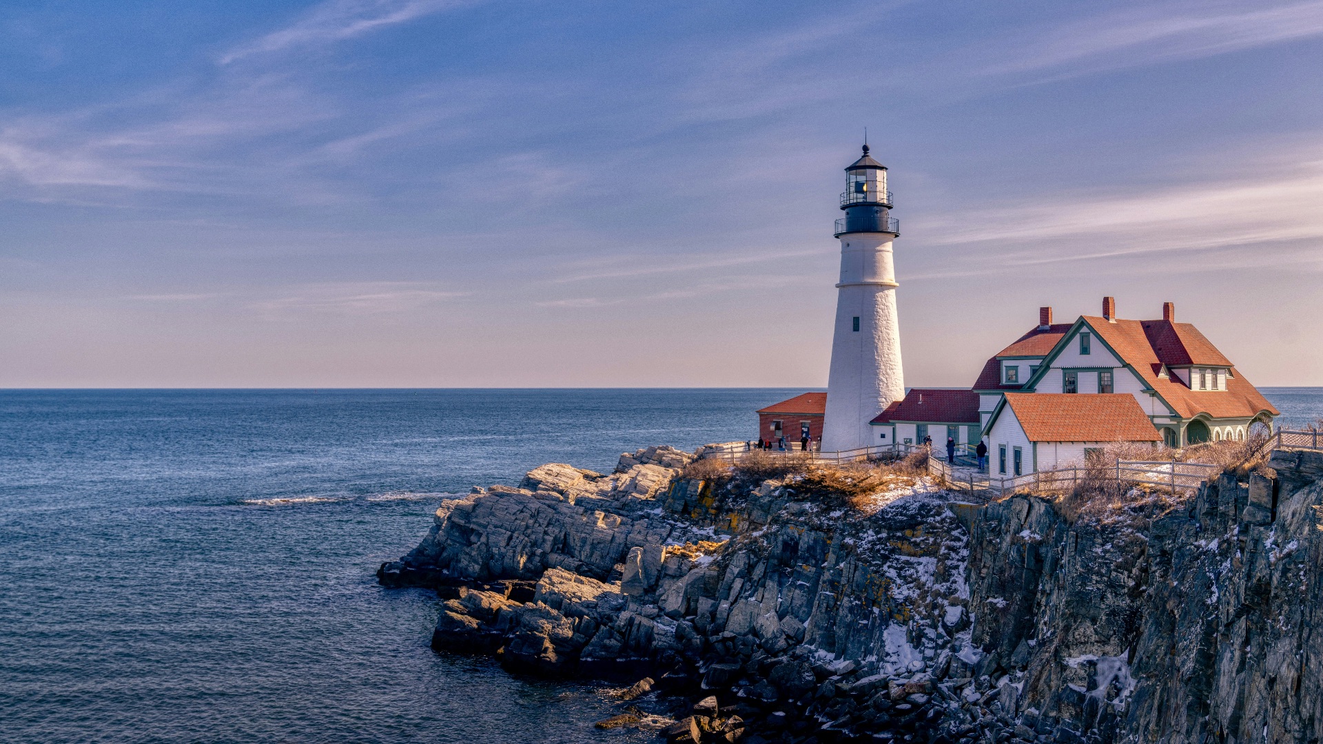 white and brown concrete house beside sea under blue sky during daytime