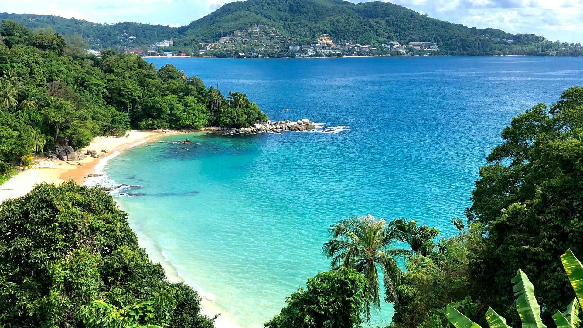 a view of a tropical beach from a hill