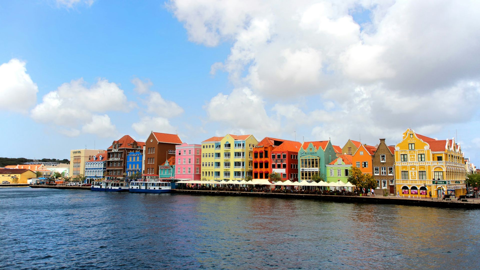 a row of colorful buildings on the side of a body of water