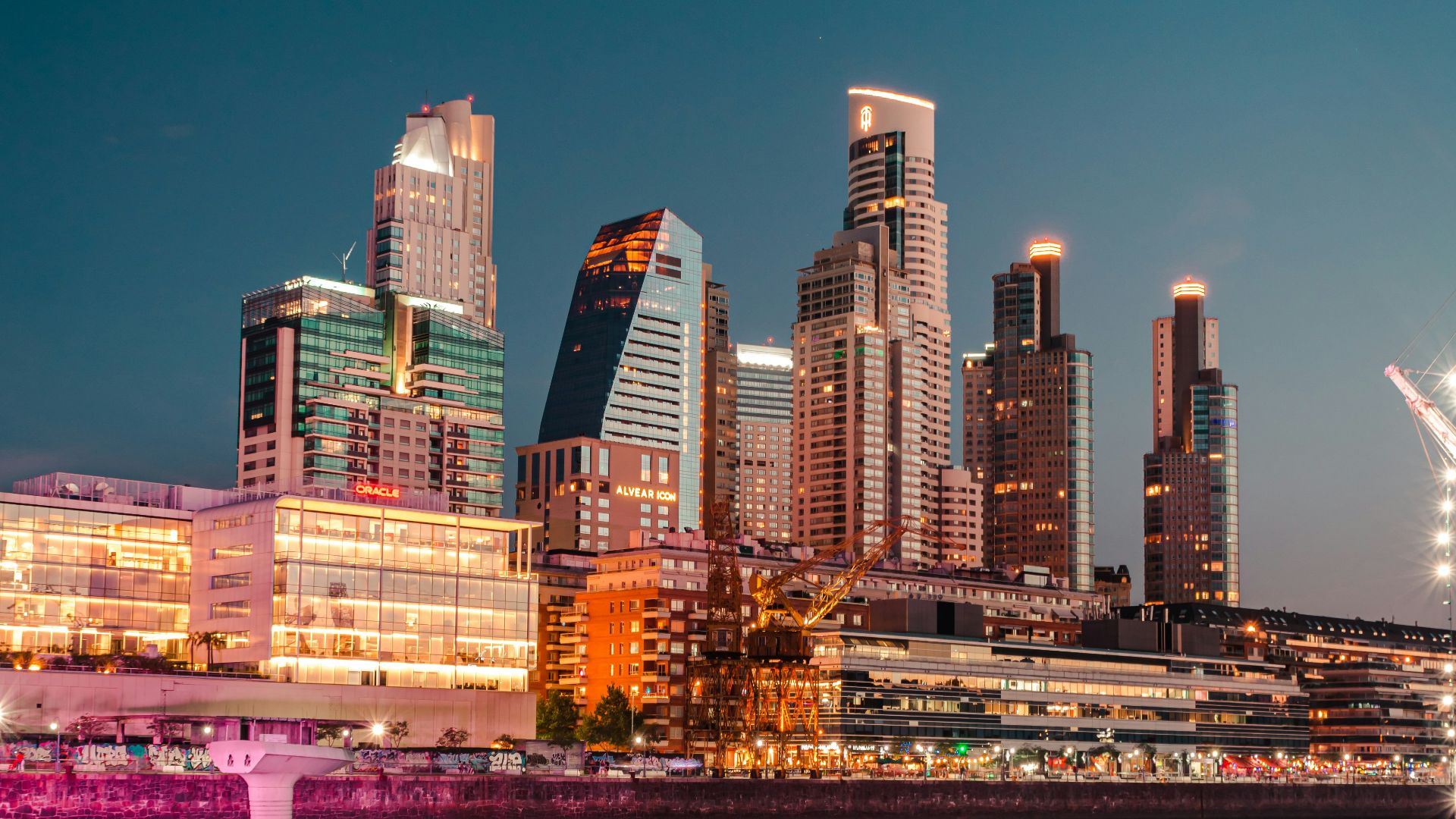city skyline across body of water during night time