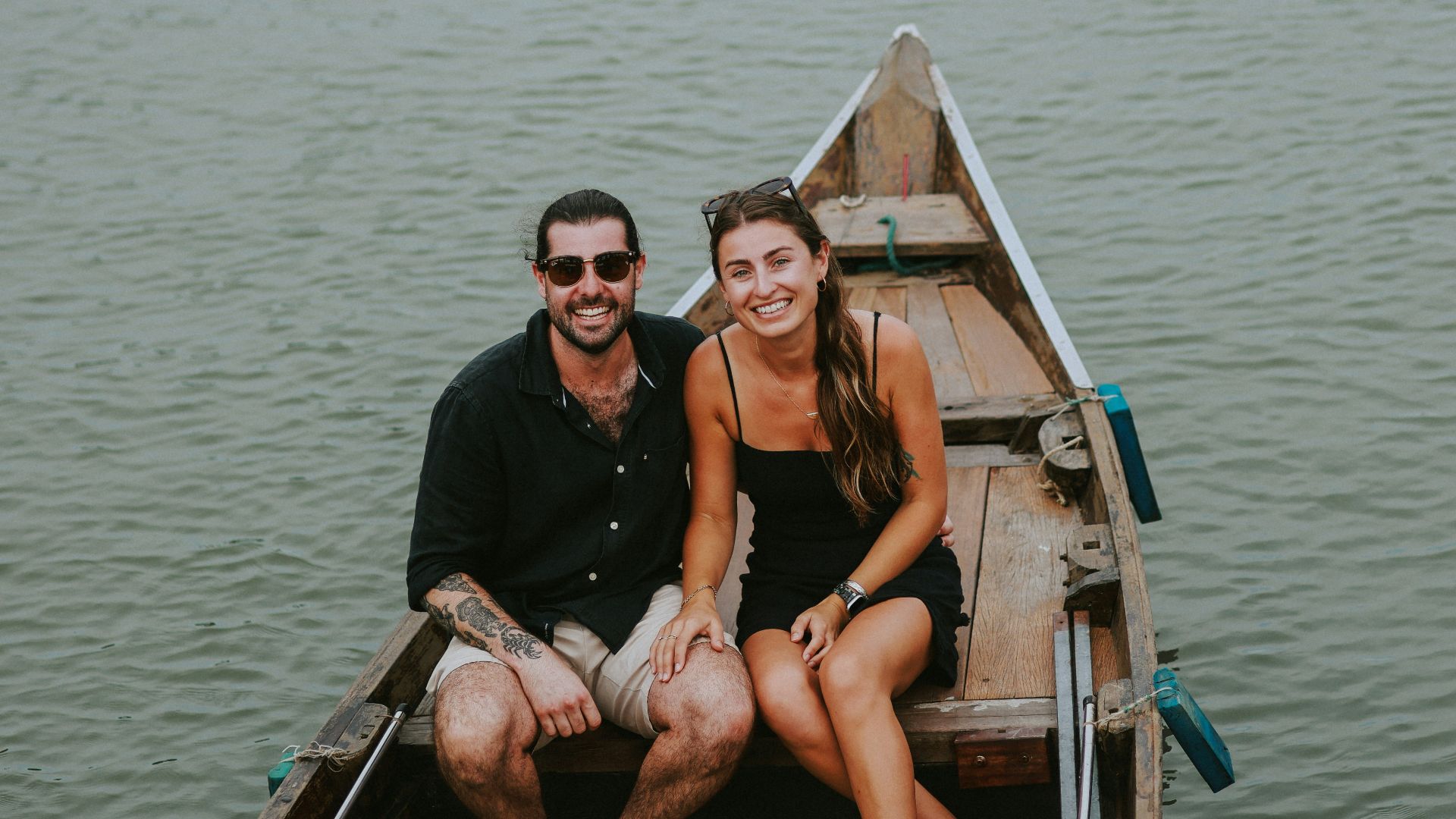a man and a woman sitting in a boat on the water