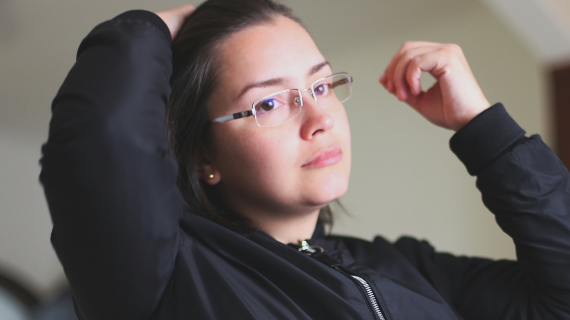 woman in black jacket wearing white earbuds