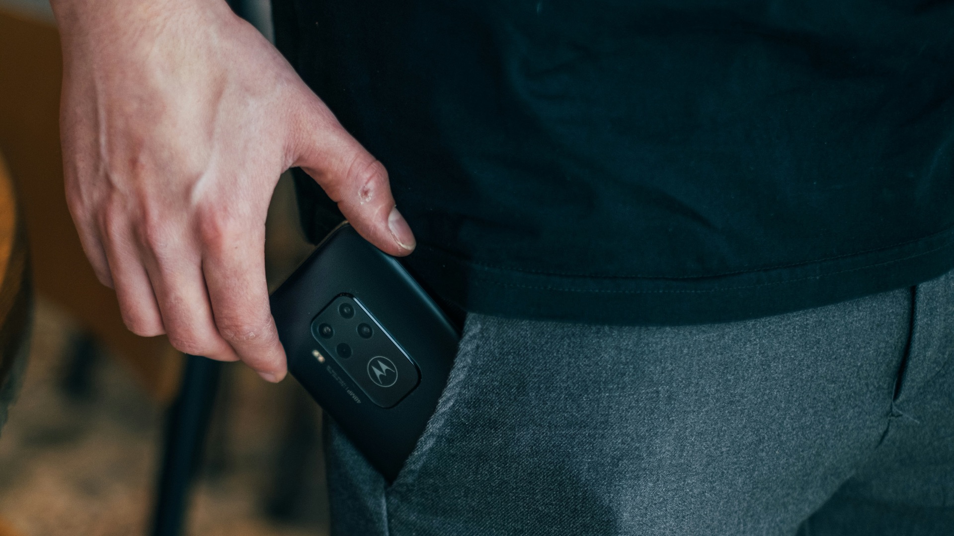person inserting smartphone in pocket