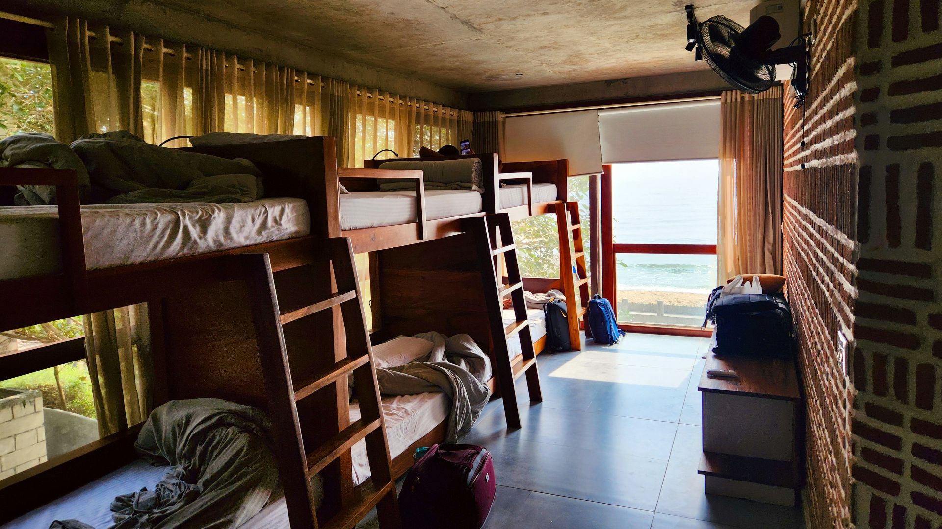 a room filled with lots of bunk beds next to a window