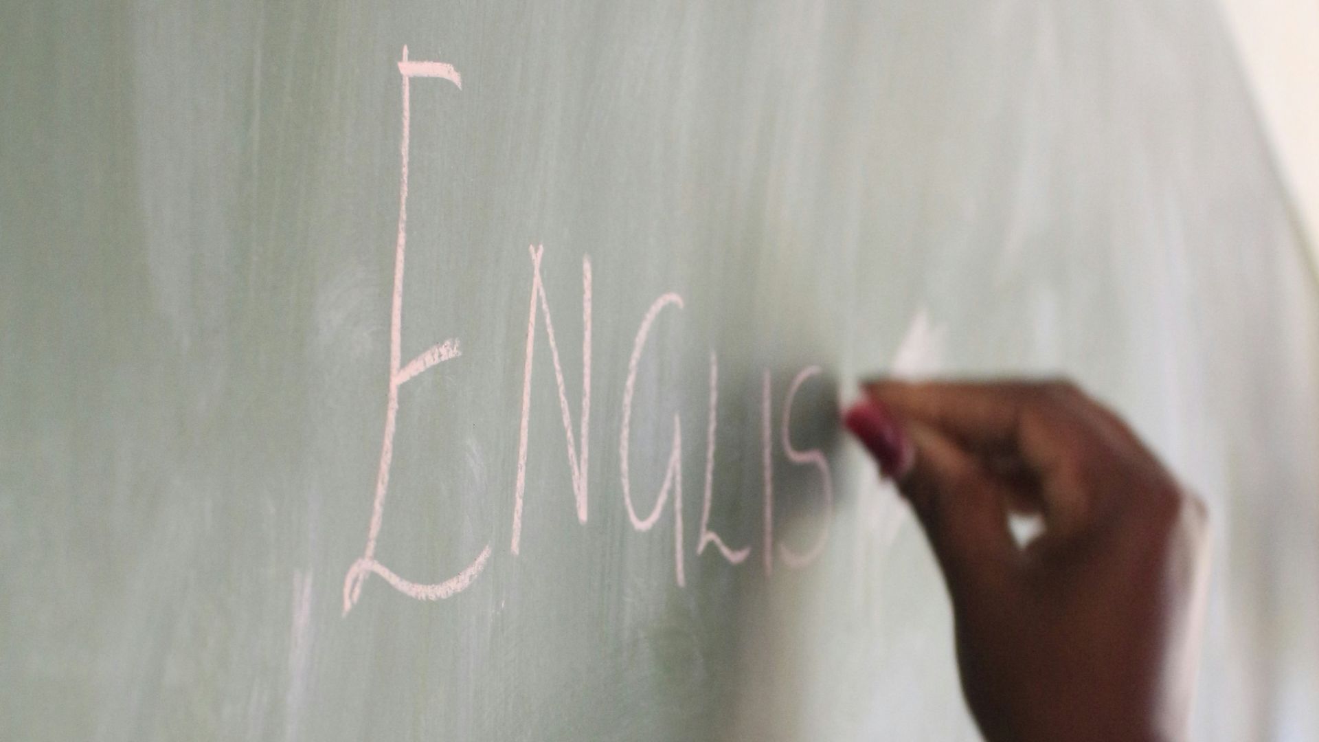 a hand writing on a chalkboard