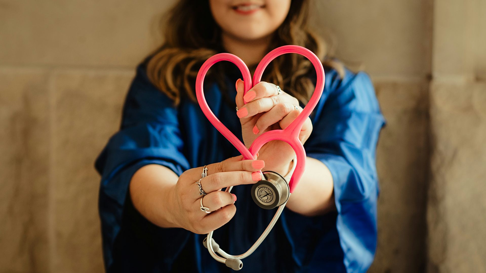 girl in blue jacket holding red and silver ring