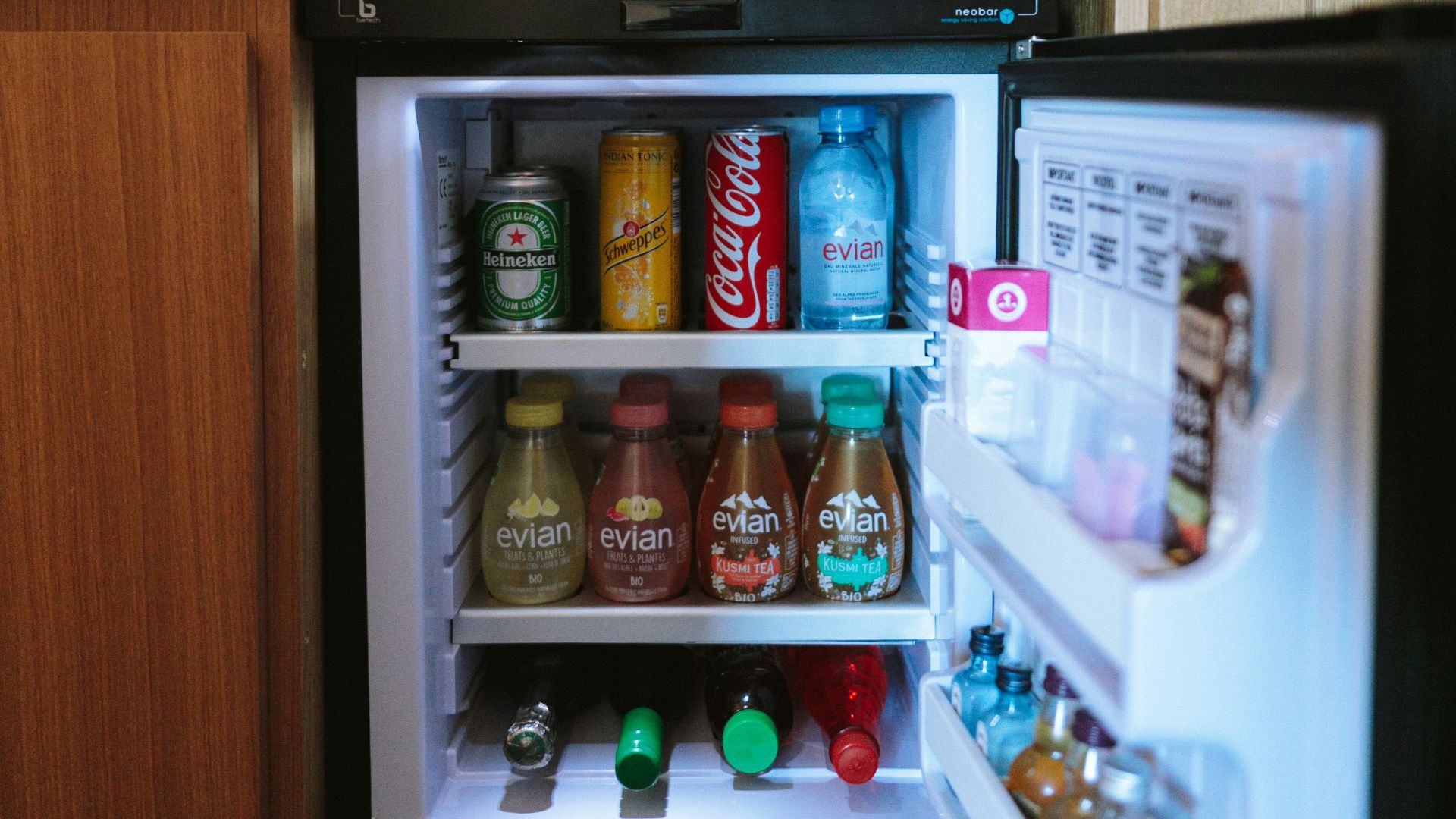 open black compact refrigerator filled with soda bottles