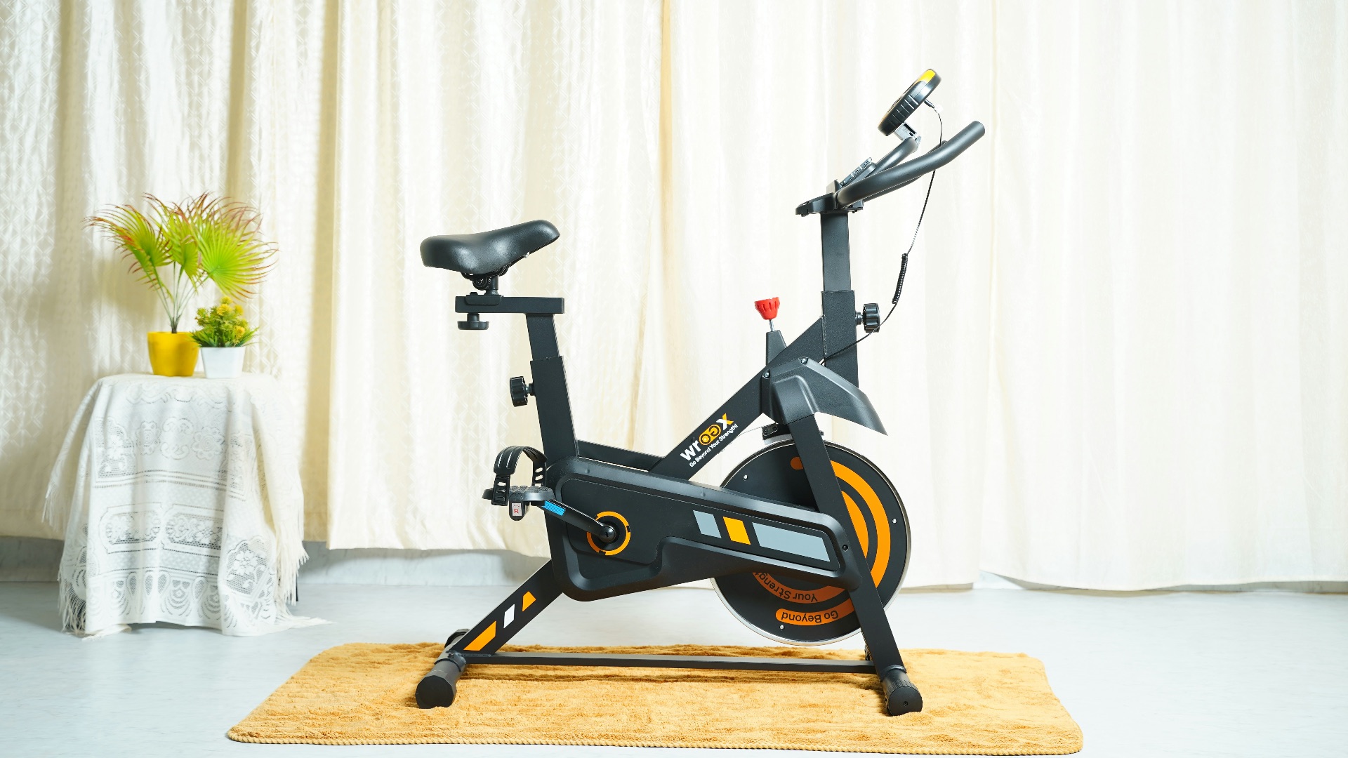 a stationary bike sits on a rug in front of a curtain