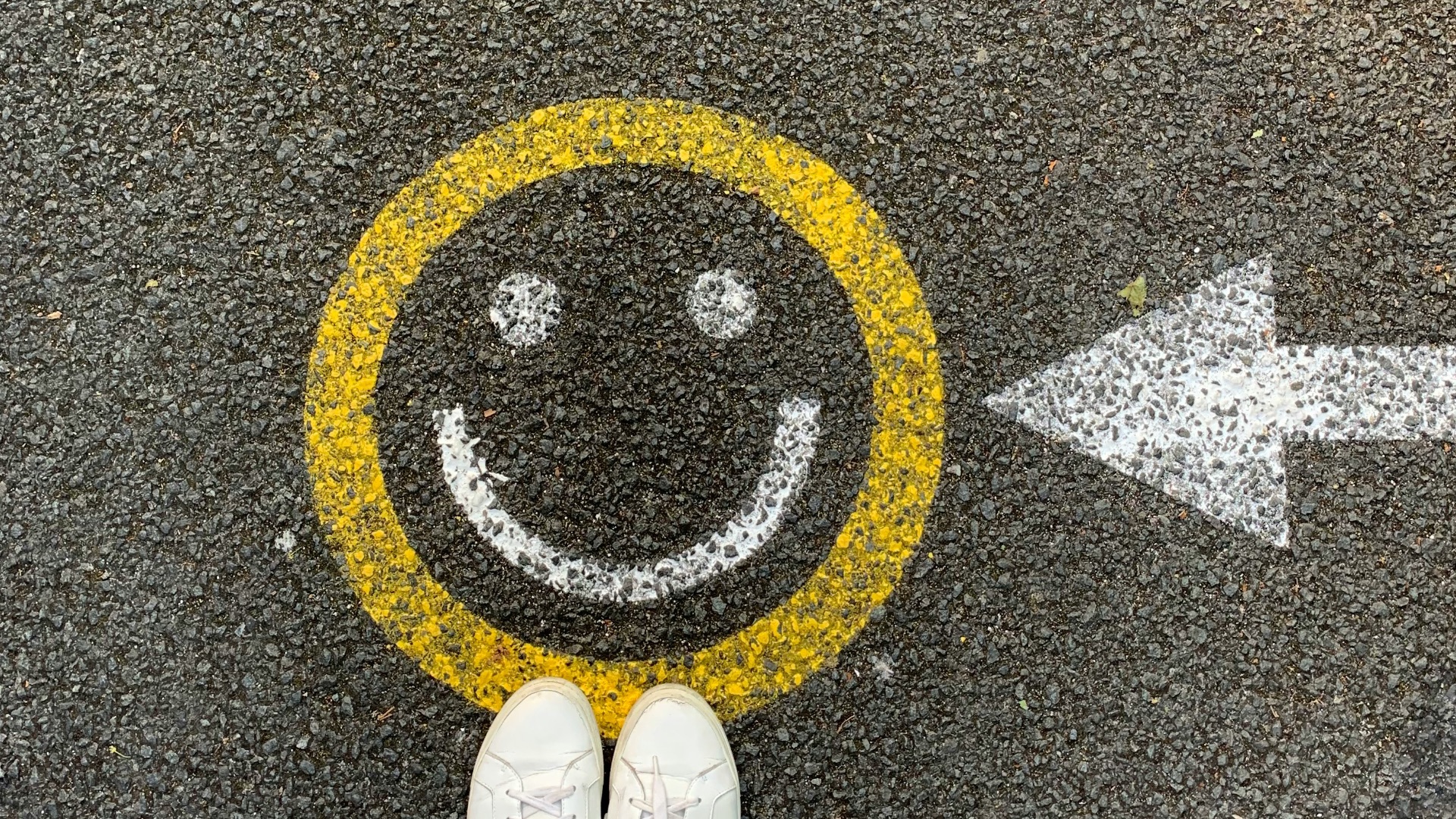person in white shoes standing on gray concrete road