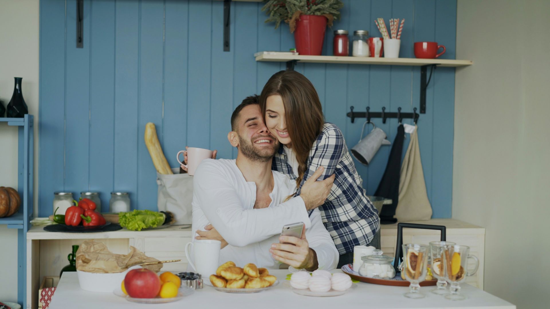Couple hugging and smiling in a kitchen.