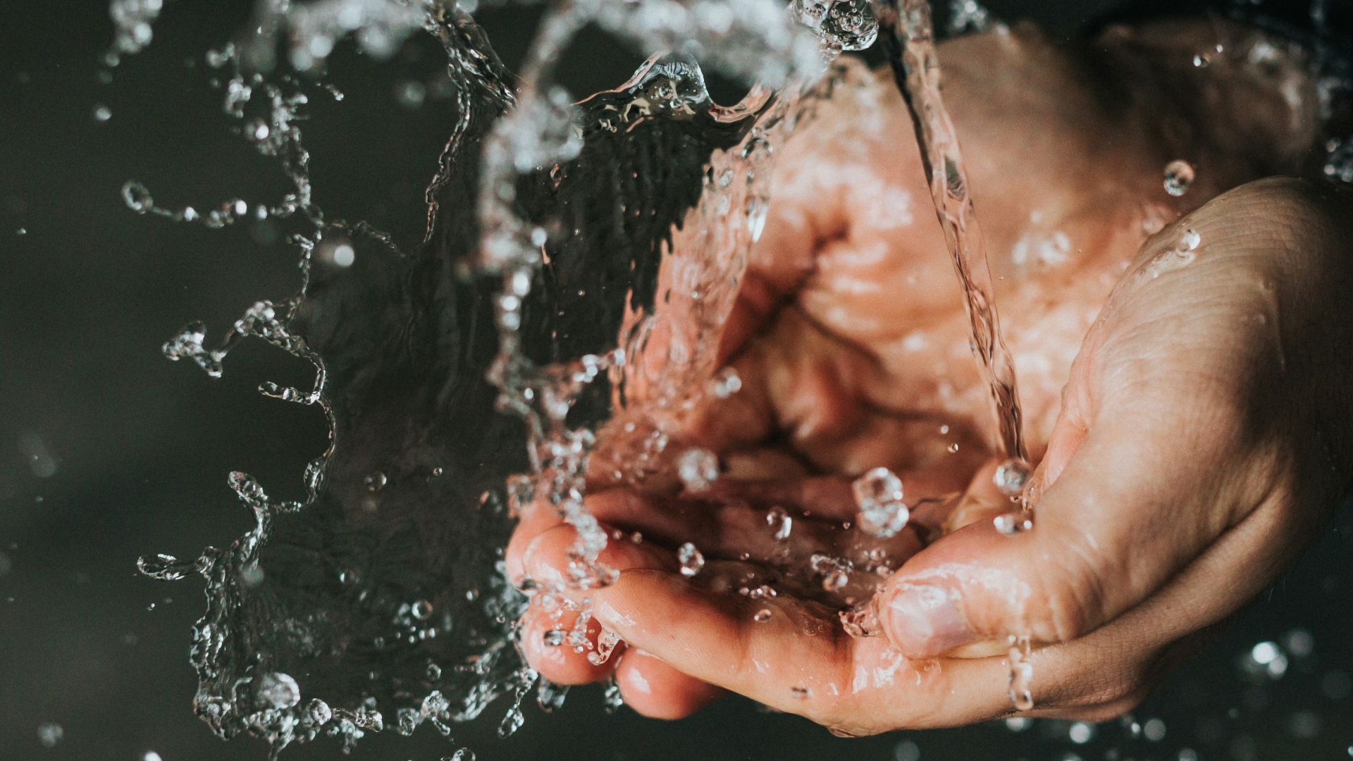 a person holding their hands under a stream of water