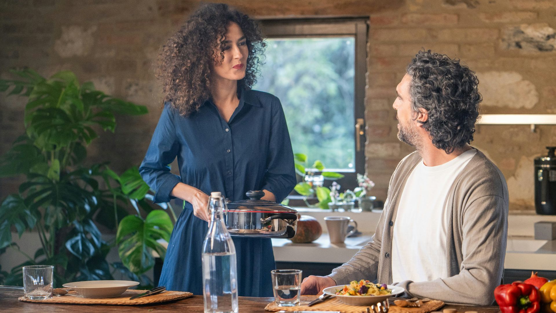 Couple cooking together in a rustic kitchen.