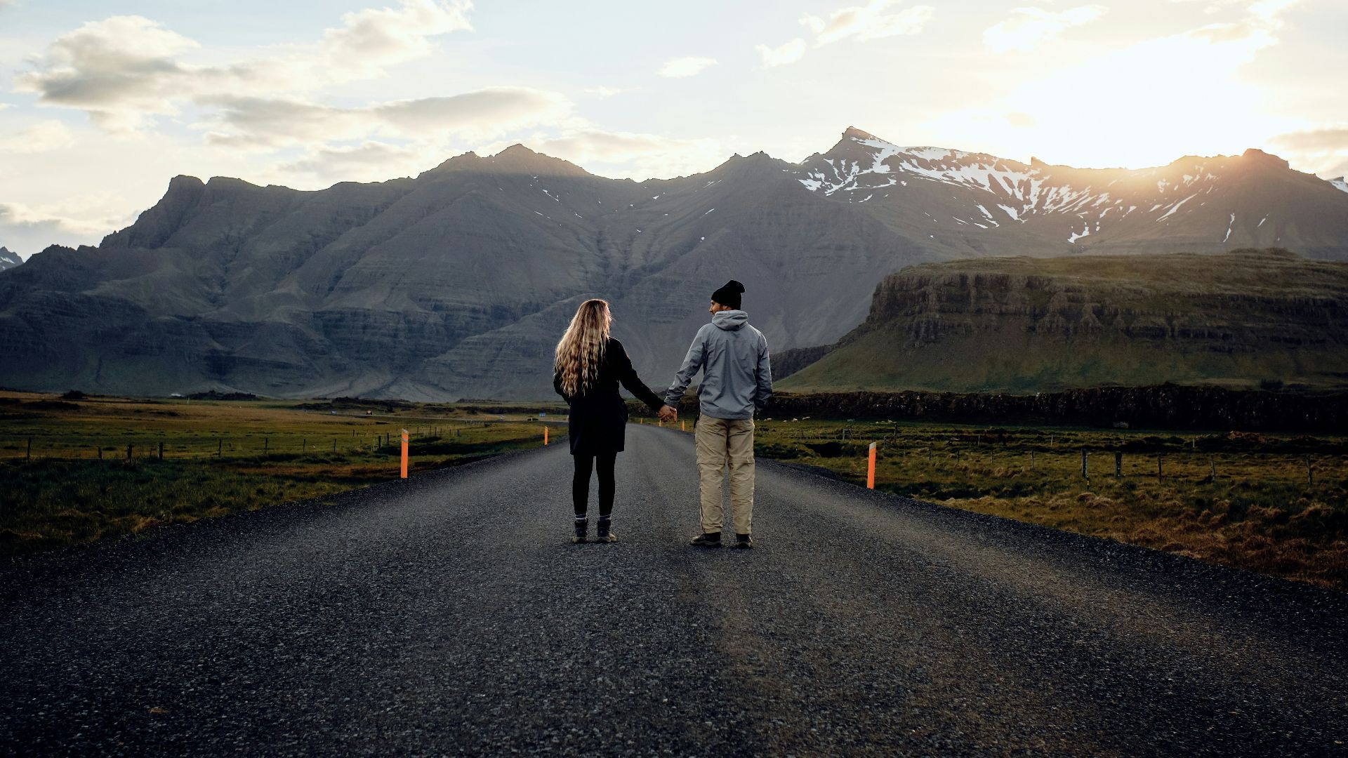 couple holding hands on road during daytime