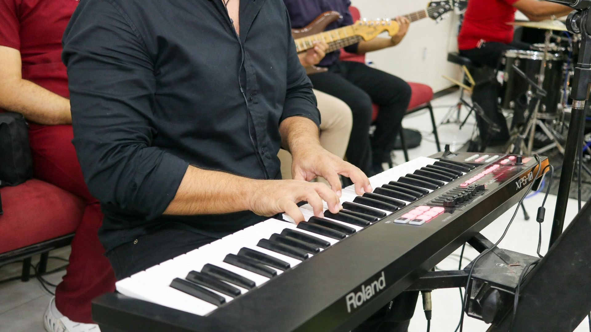 a man playing a keyboard in front of a microphone