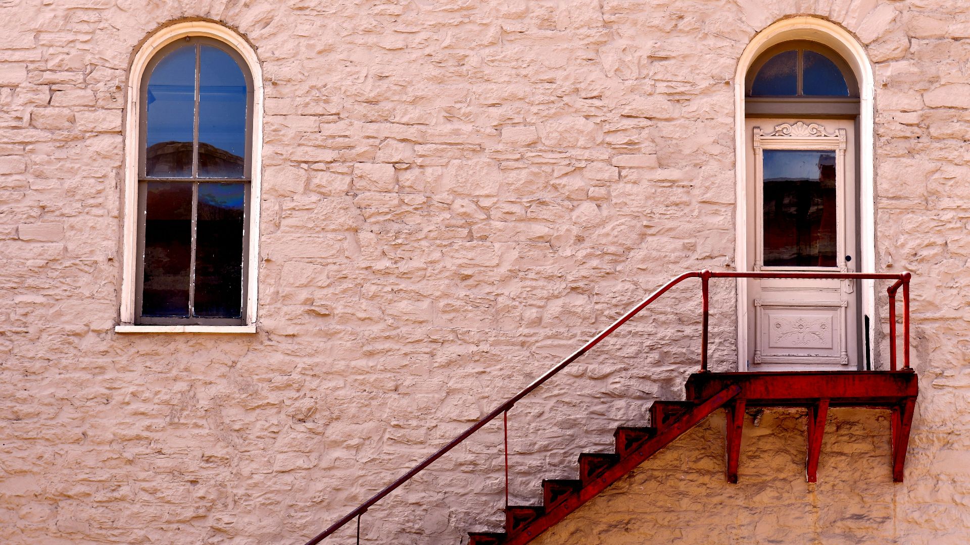 brown wooden staircase beside brown brick wall