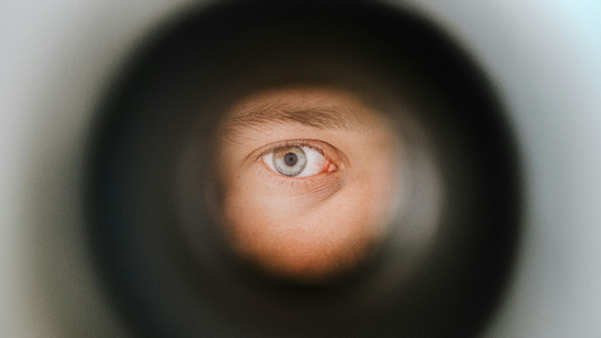 a man's eye is seen through a pipe