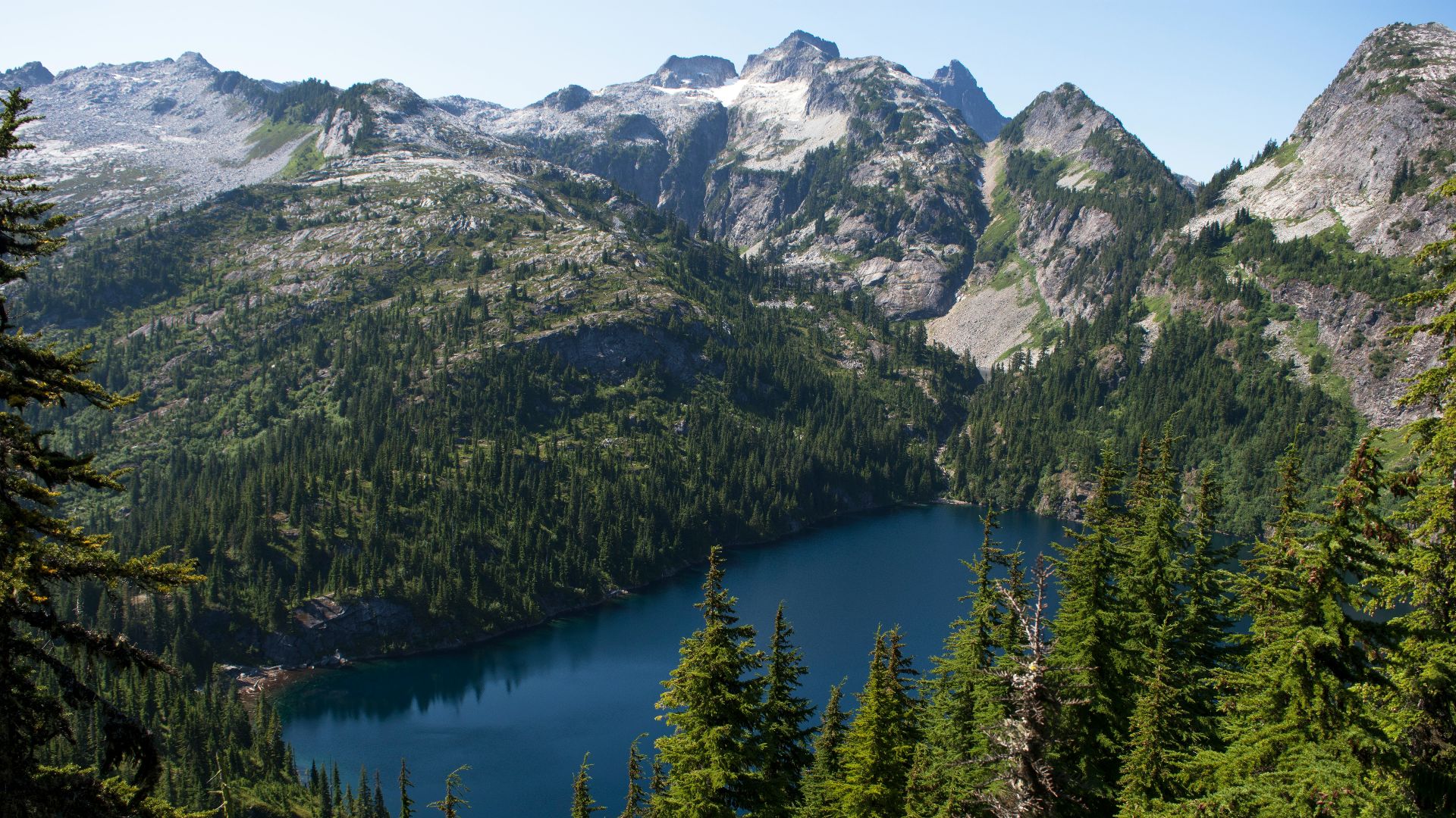 a view of a mountain lake surrounded by pine trees