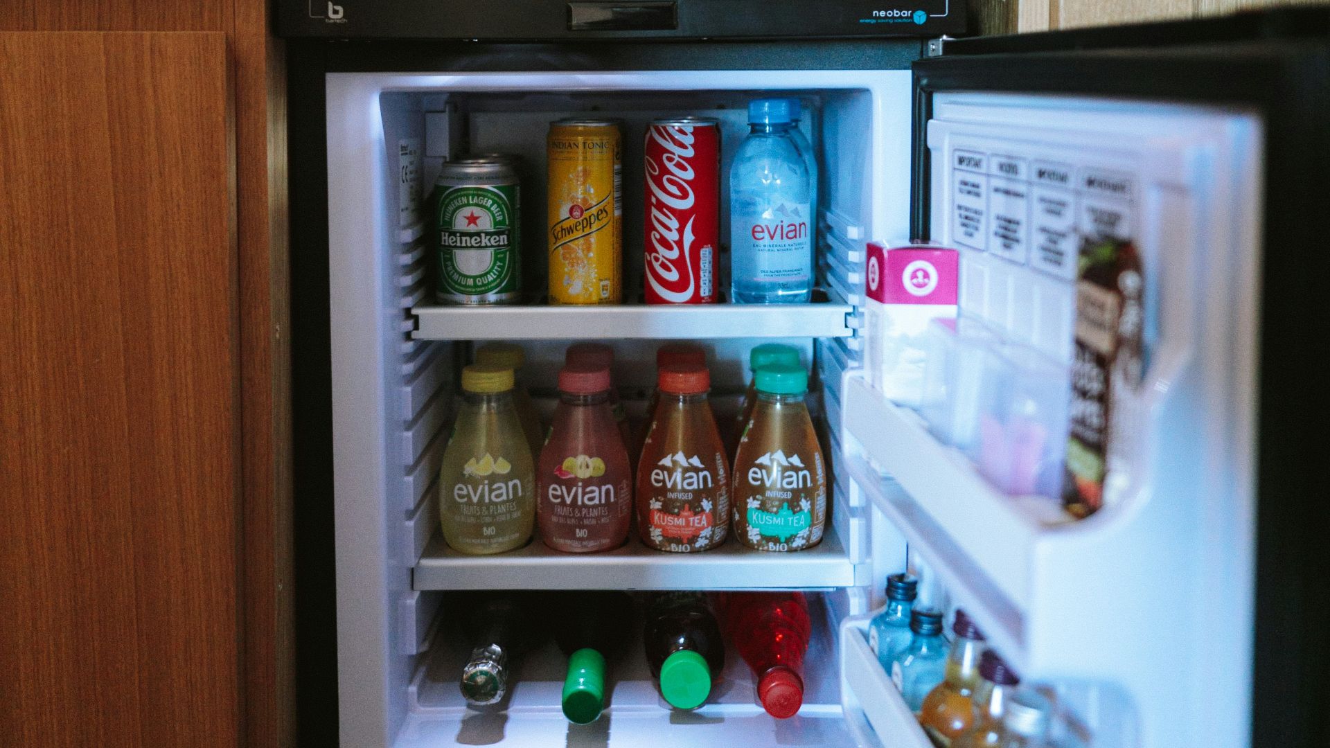 open black compact refrigerator filled with soda bottles