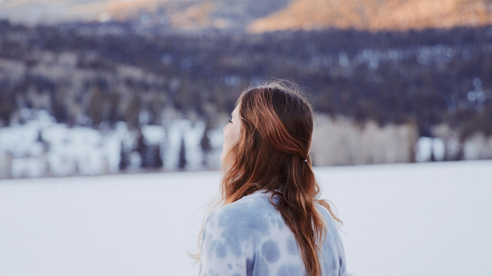 a woman standing in front of a snow covered mountain