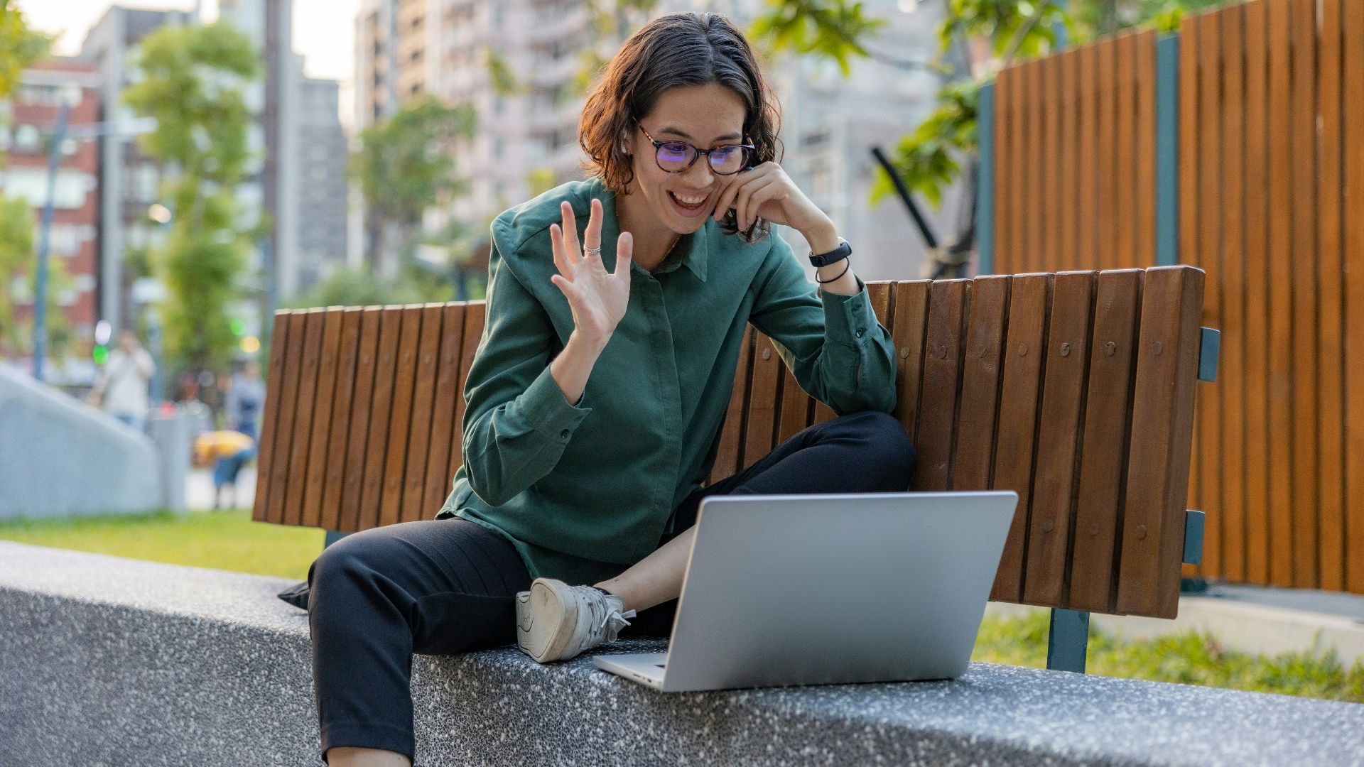 a woman sitting on a bench with a laptop