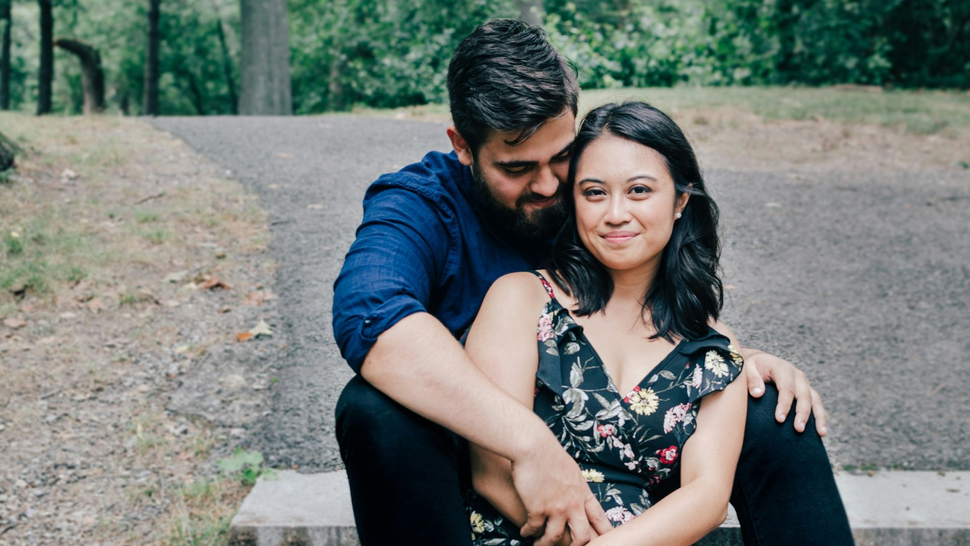man wearing blue dress shirt and black pants and woman in black floral dress