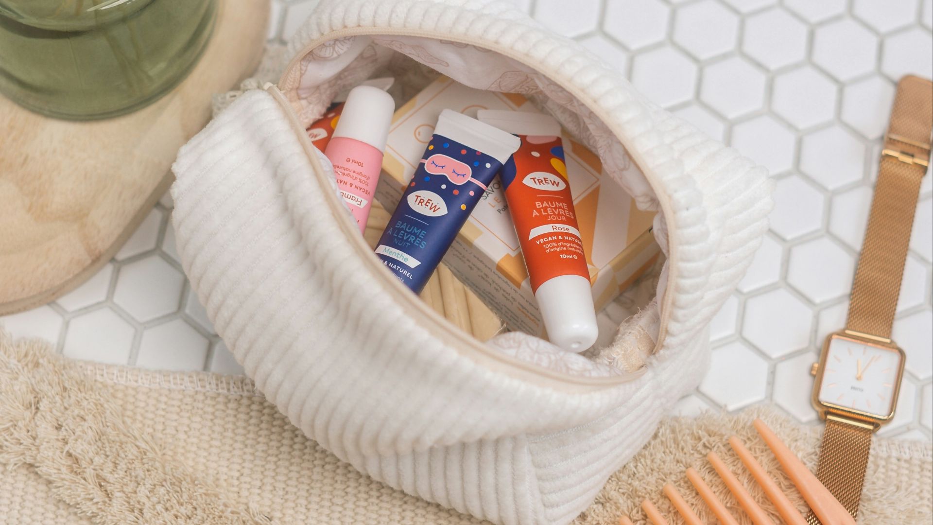 a basket of toothpaste and a toothbrush on a white towel