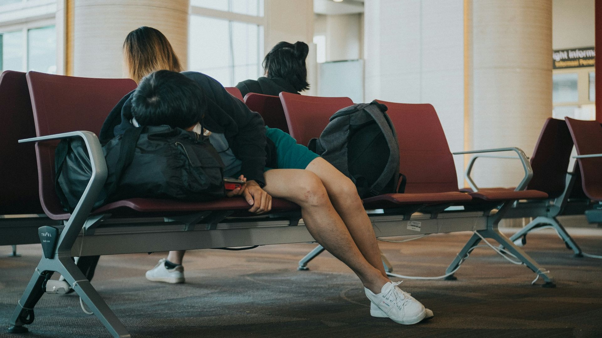 unknown person lying on brown bench indoors