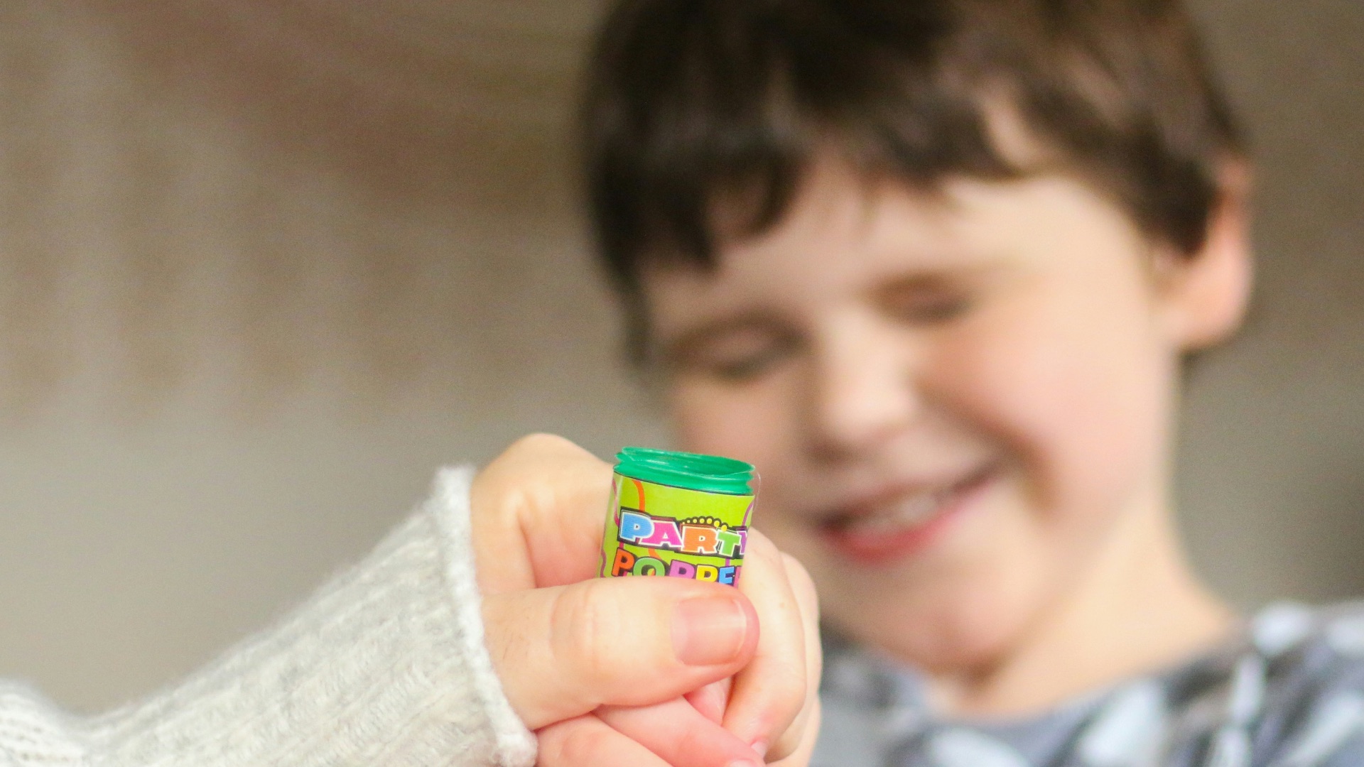 boy in black and white shirt holding yellow plastic toy