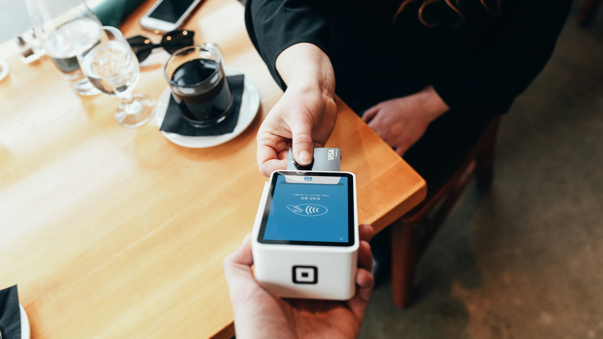 person holding credit card swipe machine