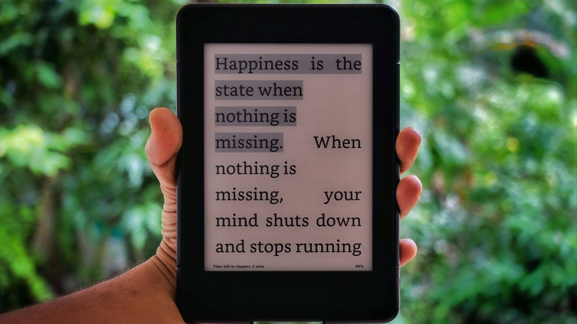 a person holding a kindle with a quote on it