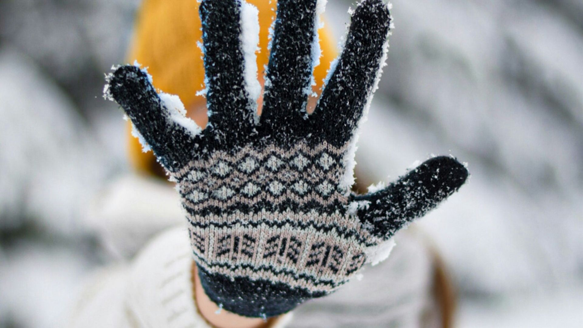 person in white and black knit gloves