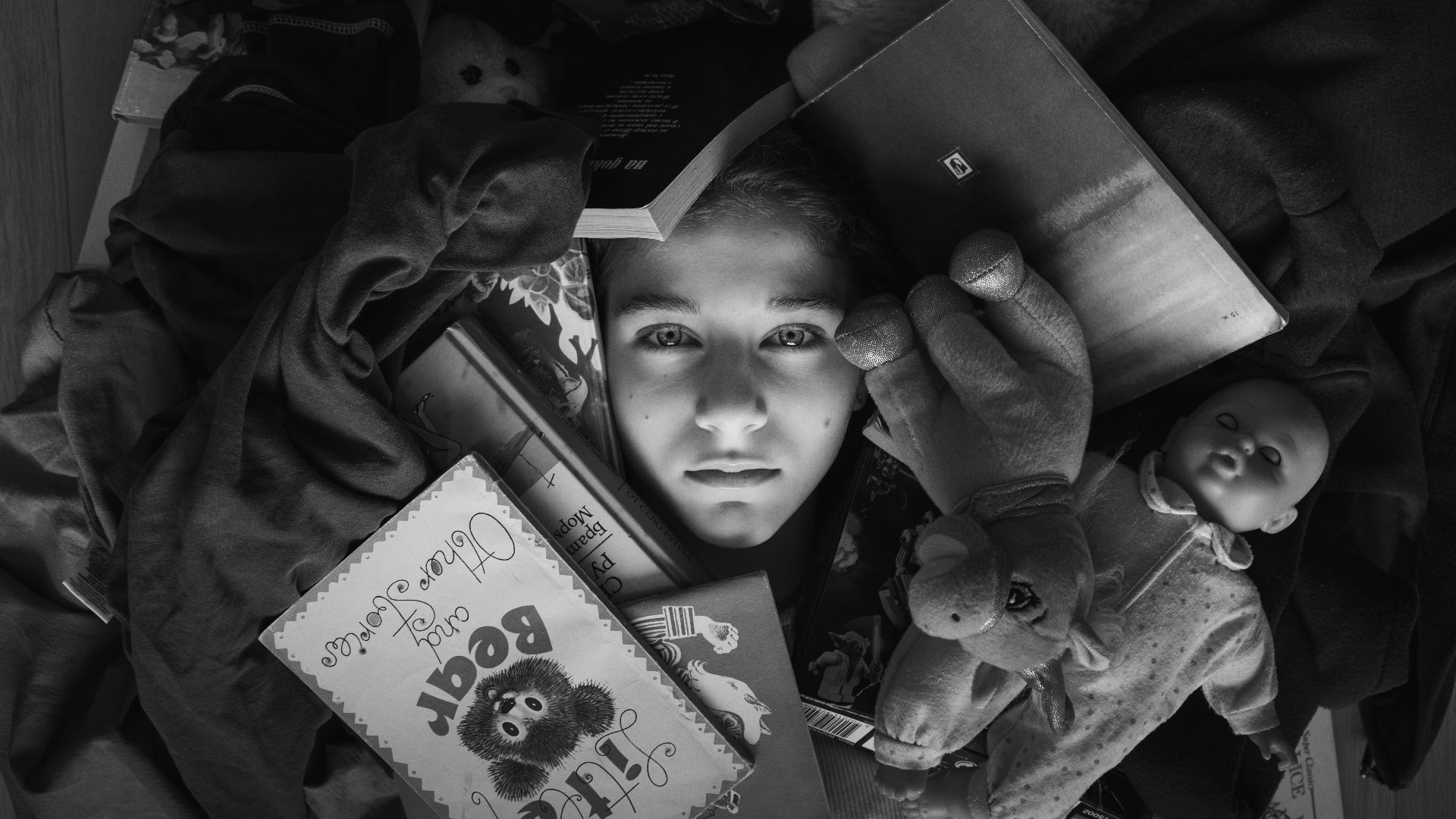 a boy holding a teddy bear and a book