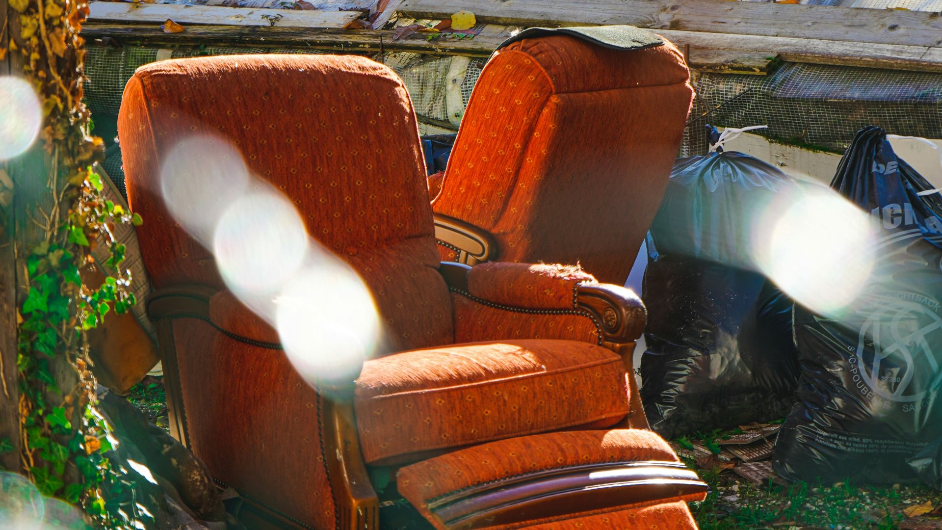 a chair outside with a wood fence in the back