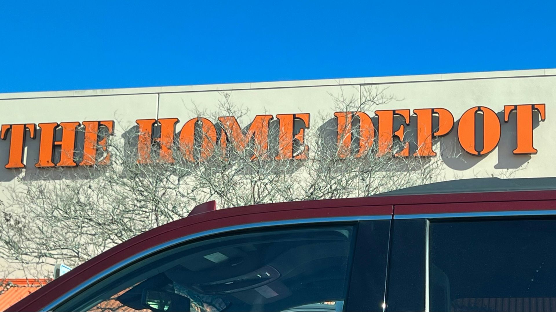 a red car parked in front of a home depot