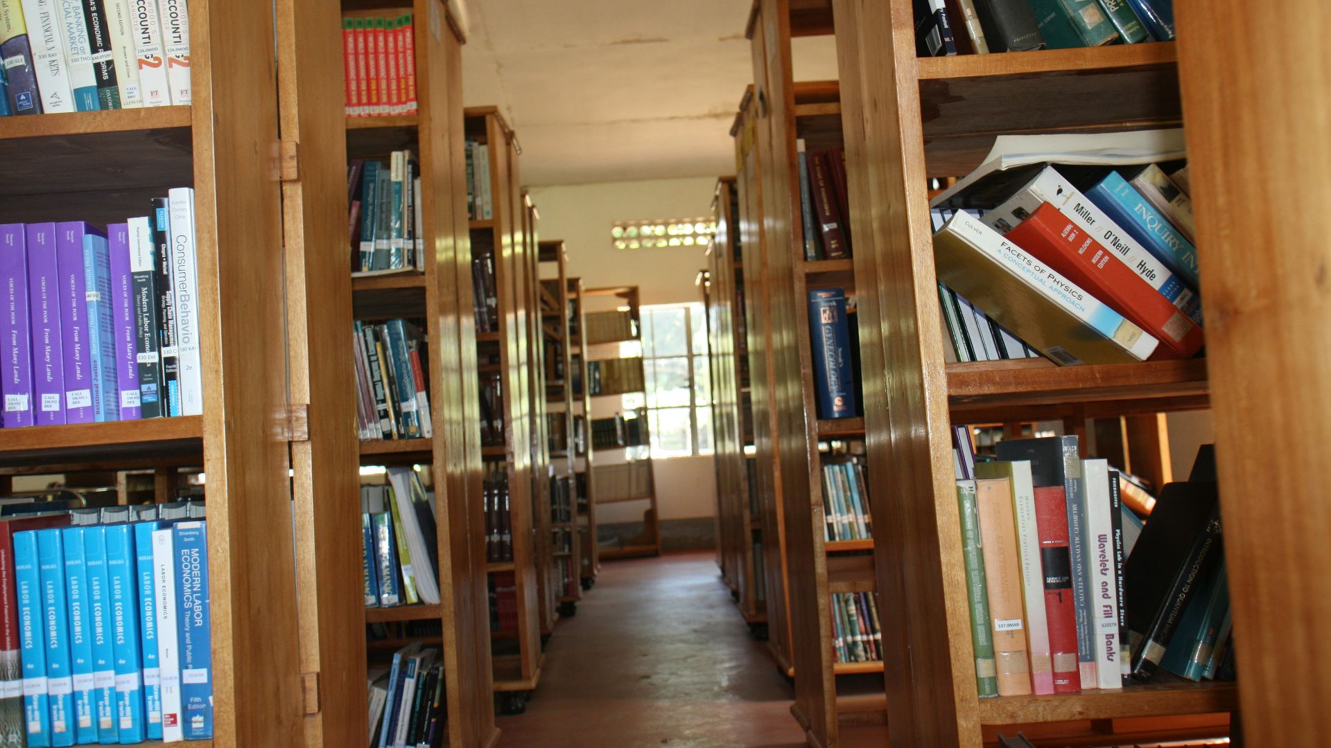 a row of wooden bookshelves filled with lots of books