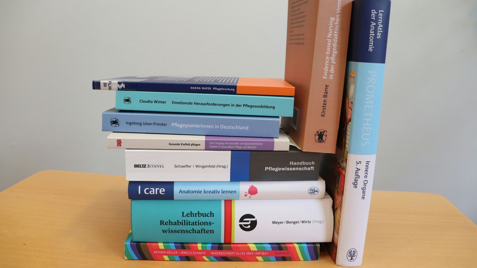 A stack of books sitting on top of a wooden table