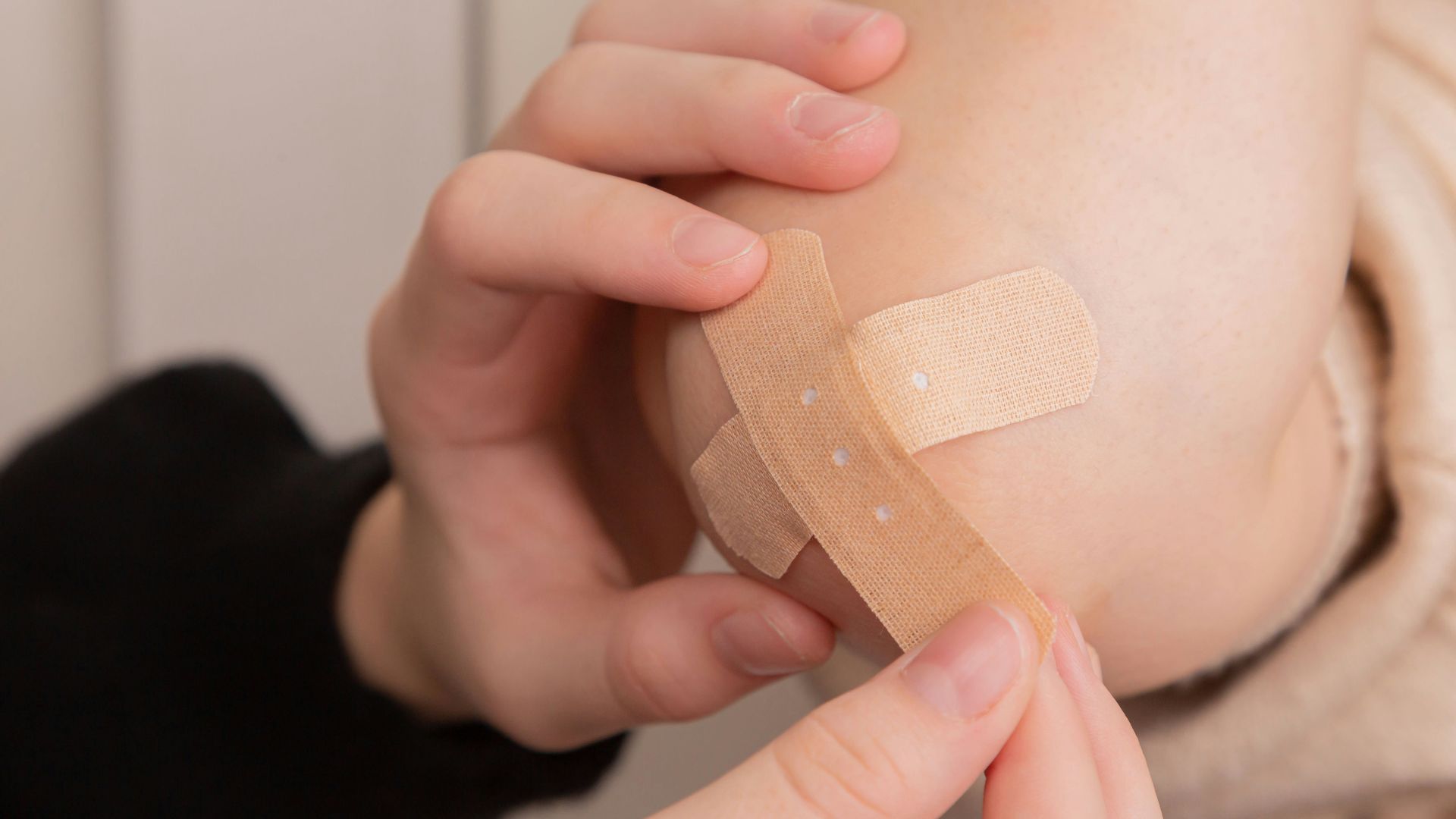 person holding band aid on left hand