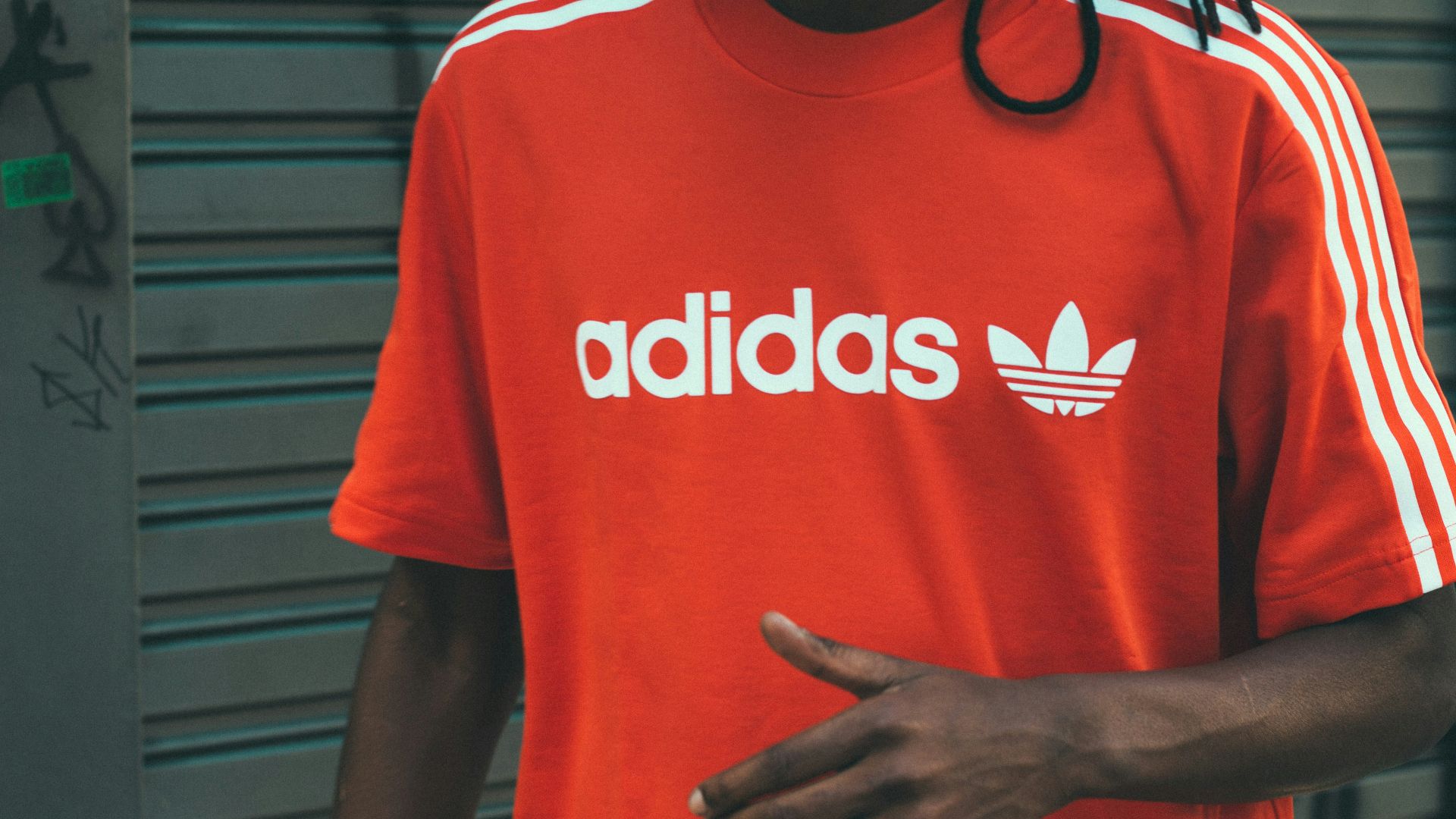 man wearing red and white adidas crew-neck T-shirt