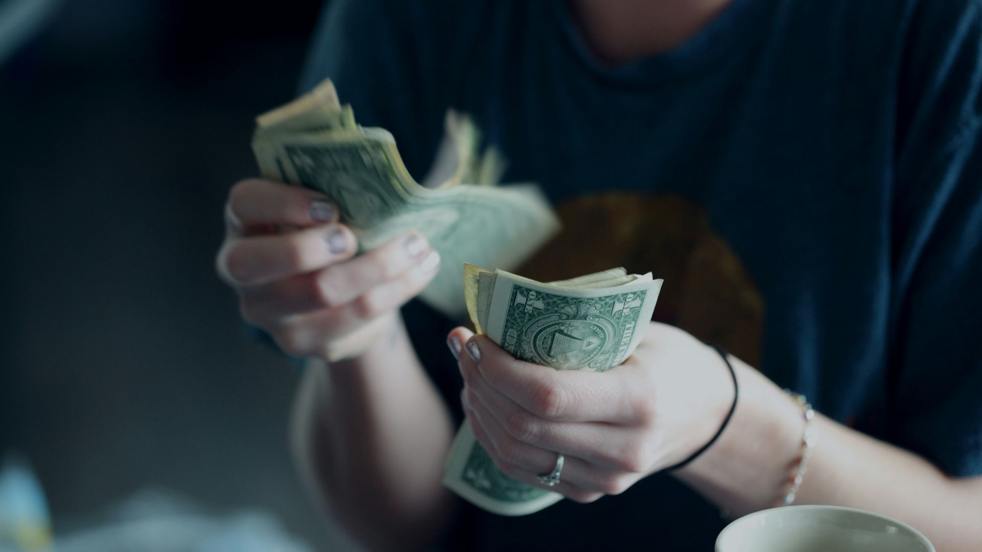 focus photography of person counting dollar banknotes