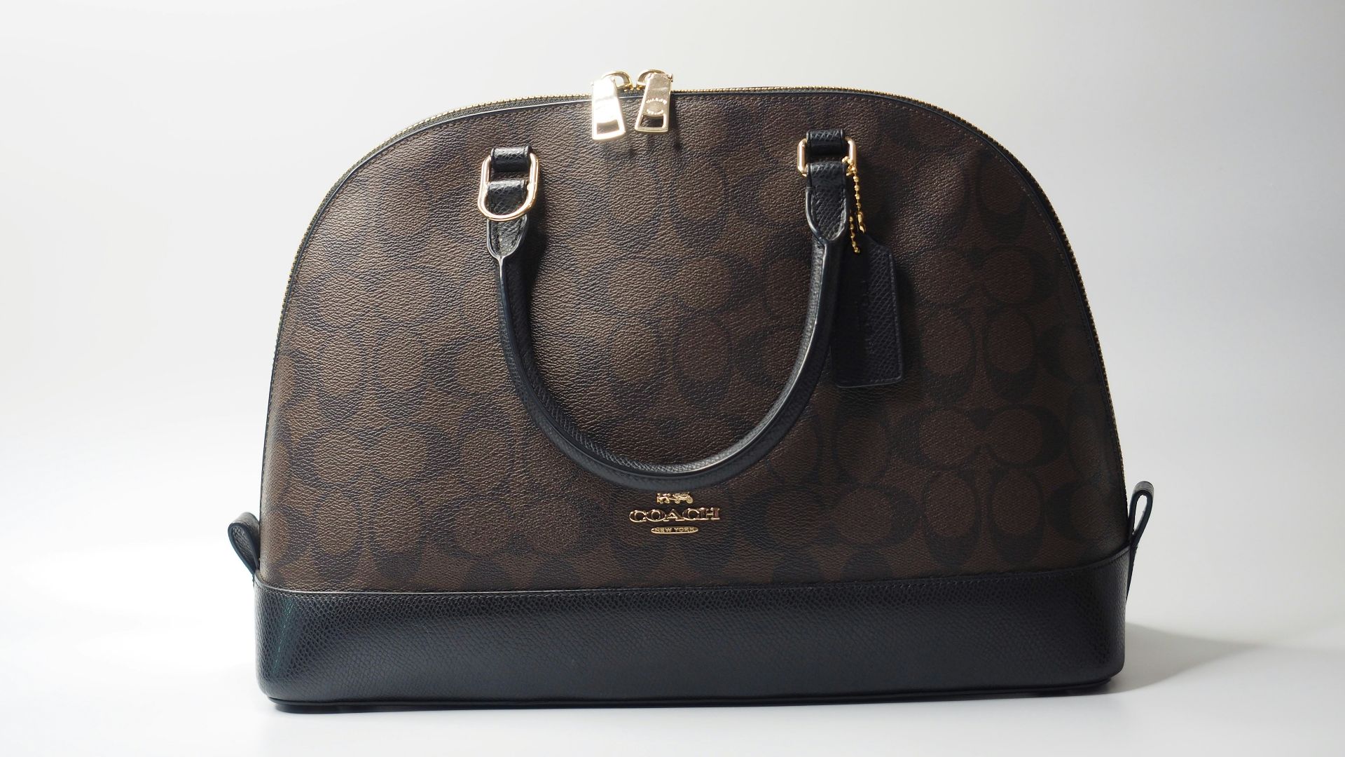 a brown and black handbag sitting on top of a white table