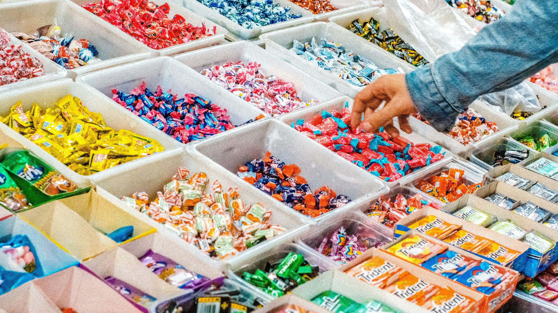person holding a candy pack on white plastic box