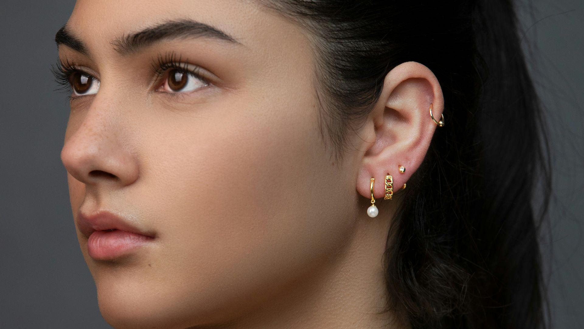 woman with silver and diamond stud earrings
