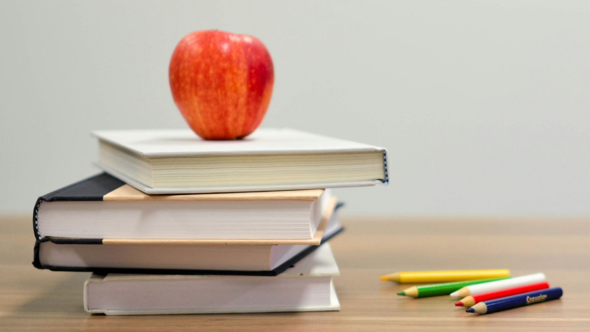 red apple fruit on four pyle books