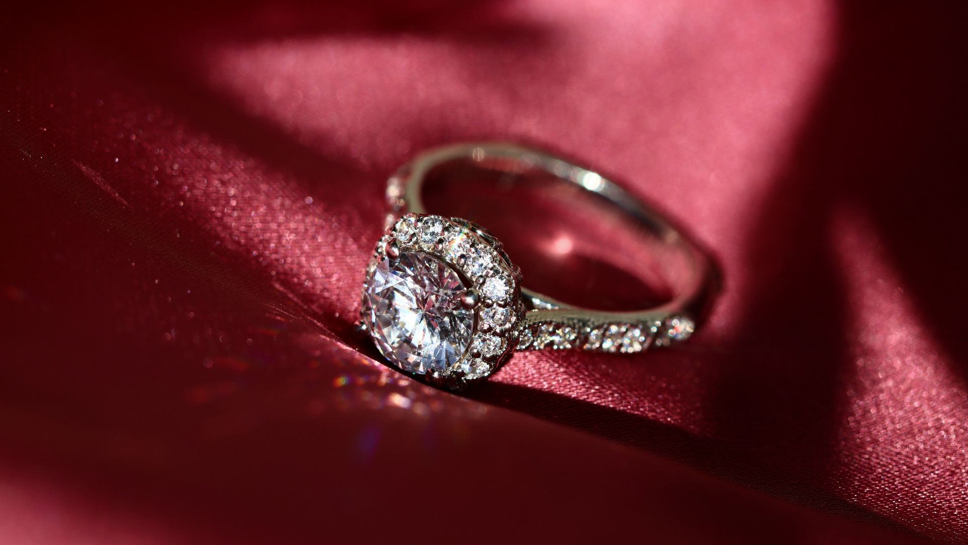 silver diamond ring on red textile
