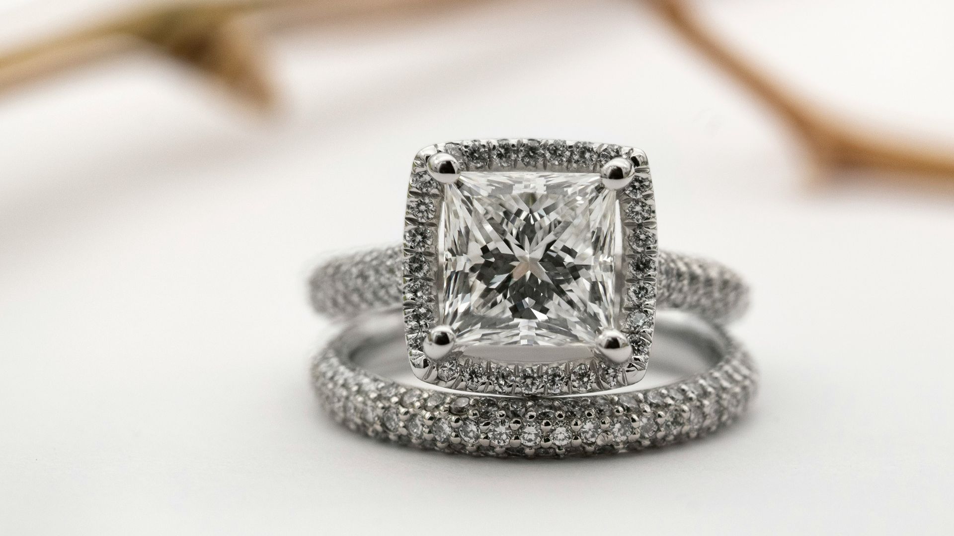 silver diamond studded ring on white surface